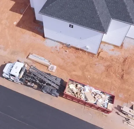 A roll-off dumpster positioned beside a construction project