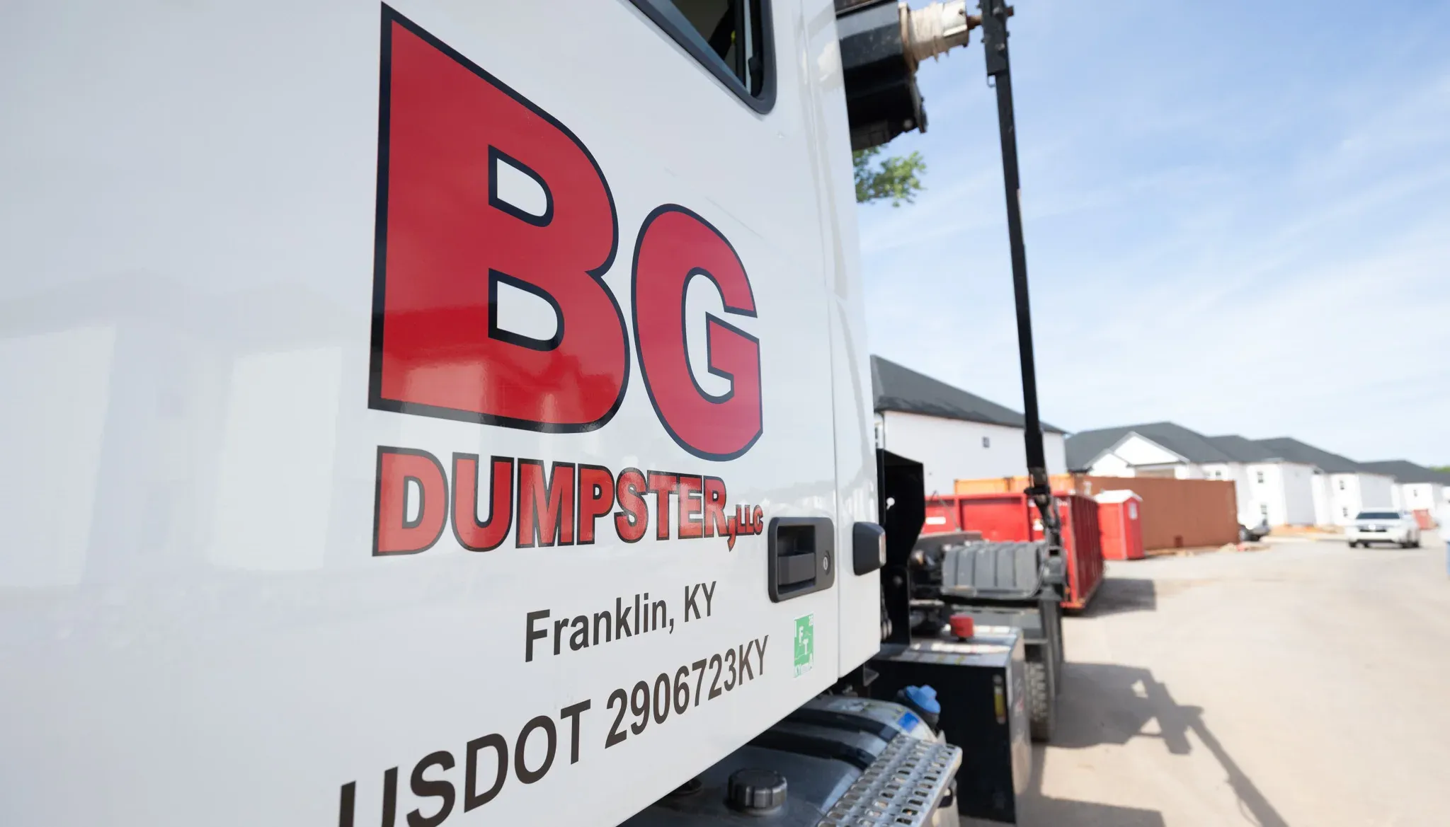 A branded BG Dumpster truck serving an industrial property