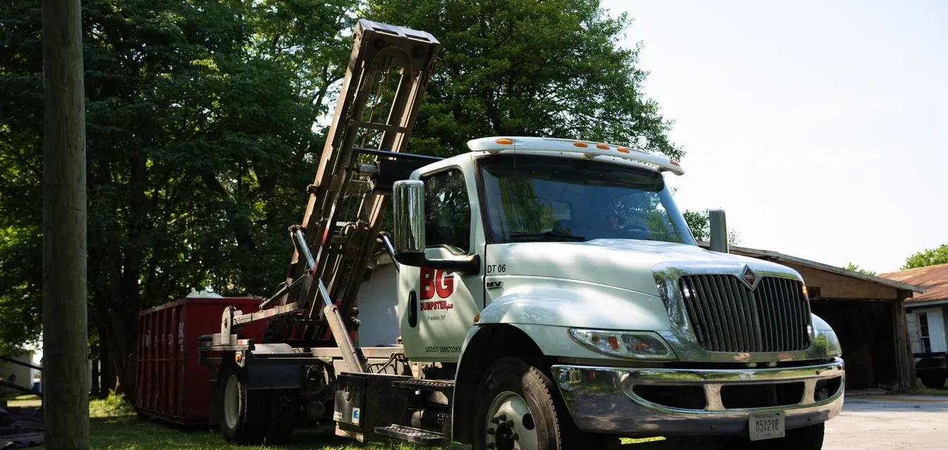 A BG Dumpster truck arriving for a property cleanup