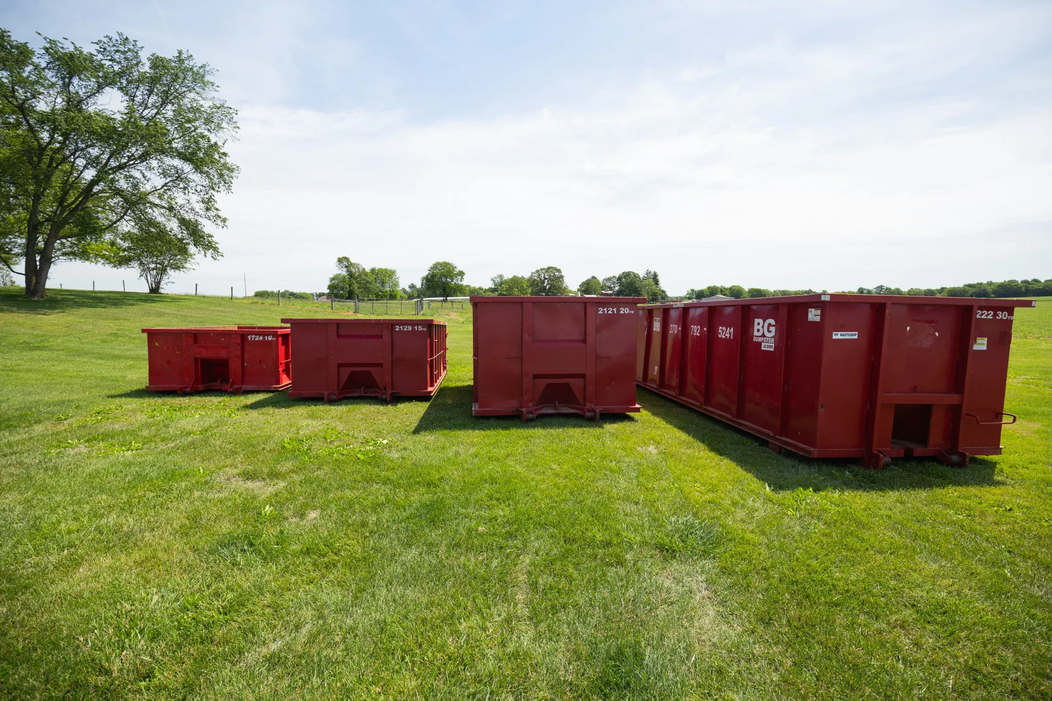 BG Dumpster roll-off containers staged in a field