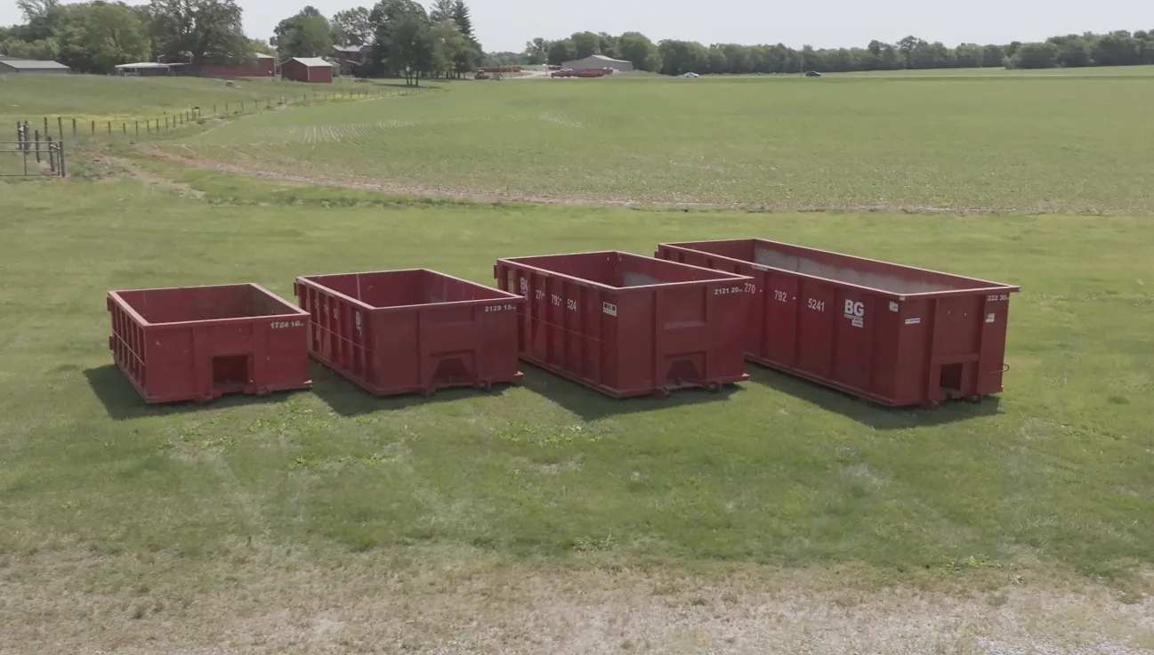 BG Dumpster roll-off containers staged in a field