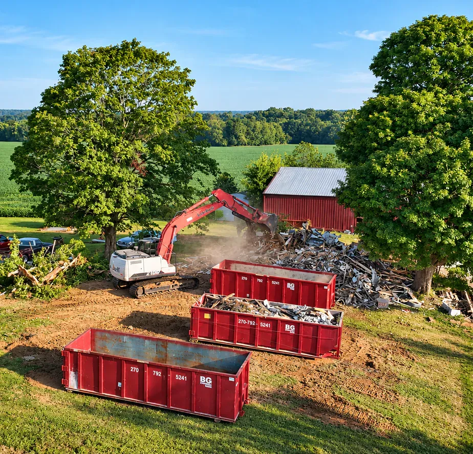 BG Dumpster roll-off containers staged beside an excavator clearing debris from a demolished structure